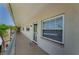 Exterior hallway featuring a security door, windows, and a well maintained walkway at 952 Virginia St # 303, Dunedin, FL 34698