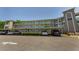 Exterior view of the condo building featuring assigned parking and well maintained landscaping at 952 Virginia St # 303, Dunedin, FL 34698