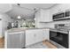 Modern kitchen featuring stainless steel appliances, granite countertops, and white cabinets at 952 Virginia St # 303, Dunedin, FL 34698