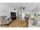 Bright living room featuring wood-look floors, neutral furnishings, and a ceiling fan at 952 Virginia St # 303, Dunedin, FL 34698