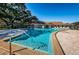 Inviting community pool with lounge chairs and trees, perfect for relaxation at 952 Virginia St # 303, Dunedin, FL 34698