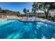 Beautiful community pool with lounge chairs and palm trees under a clear sky at 952 Virginia St # 303, Dunedin, FL 34698