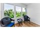 Bright sunroom featuring wood floors, three large windows, and stylish black wicker furniture at 952 Virginia St # 303, Dunedin, FL 34698