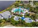 Aerial view of a resort-style community pool, splashpad, and clubhouse overlooking a lake at 11038 Spring Point Cir, Riverview, FL 33579