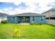 A backyard featuring a covered patio, a blue house and a well-manicured lawn at 11038 Spring Point Cir, Riverview, FL 33579