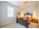 A cozy bedroom with a dark wood frame bed and a window with blinds at 11038 Spring Point Cir, Riverview, FL 33579