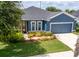 Charming blue single-story home with well-maintained landscaping and a spacious two-car garage at 11038 Spring Point Cir, Riverview, FL 33579