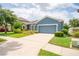 Charming blue single-Gathering home featuring a two-car garage, stone accents, and a well-manicured front yard at 11038 Spring Point Cir, Riverview, FL 33579