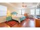 Bright main bedroom with tray ceilings, hardwood floors, and many windows allowing natural light at 11038 Spring Point Cir, Riverview, FL 33579