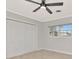 Bedroom features closet with bi-fold doors, window, and ceiling fan at 111 Carlyle Dr, Palm Harbor, FL 34683