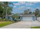 Charming single-story home featuring a two-car garage, manicured lawn, and beautiful landscaping at 111 Carlyle Dr, Palm Harbor, FL 34683