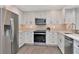 Modern kitchen featuring stainless steel appliances, updated countertops, and shaker style cabinets at 111 Carlyle Dr, Palm Harbor, FL 34683