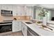 Bright kitchen with stainless steel dishwasher, shaker cabinets, and modern fixtures at 111 Carlyle Dr, Palm Harbor, FL 34683