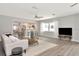 Open living area with kitchen view, ceiling fan, and natural light from a window at 111 Carlyle Dr, Palm Harbor, FL 34683