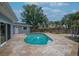 Backyard oasis featuring a private pool surrounded by a stone paver patio and lush landscaping at 111 Carlyle Dr, Palm Harbor, FL 34683