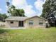 Expansive backyard with mature trees, a well-maintained lawn, and a concrete patio for outdoor relaxation at 12615 Logan Pl, Tampa, FL 33625