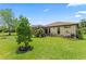 Landscaped backyard features a lush lawn, mature trees, and an inviting screened-in patio at 137 Silver Falls Dr, Apollo Beach, FL 33572