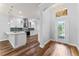Elegant entryway connecting to a modern kitchen with an open-concept design and hardwood floors at 137 Silver Falls Dr, Apollo Beach, FL 33572