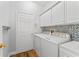 Clean laundry room with updated washer and dryer, plus storage cabinets at 137 Silver Falls Dr, Apollo Beach, FL 33572