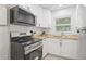 Bright kitchen with white cabinets, butcher block counters, stainless appliances, and subway tile backsplash at 1401 30Th N Ave, St Petersburg, FL 33704