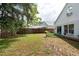 A fenced backyard with grass, and a small planted area near the house at 1421 Dew Bloom Rd, Valrico, FL 33594
