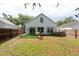 A well-kept fenced backyard with grass and a view of the home's rear at 1421 Dew Bloom Rd, Valrico, FL 33594