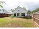 A well-kept fenced backyard with grass and a view of the home's rear at 1421 Dew Bloom Rd, Valrico, FL 33594