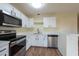 Bright kitchen showcasing stainless steel appliances, white cabinetry, and a convenient breakfast bar at 1421 Dew Bloom Rd, Valrico, FL 33594