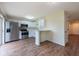 Bright kitchen featuring stainless appliances, white cabinets, and wood-look floors at 1421 Dew Bloom Rd, Valrico, FL 33594