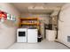 Laundry room featuring a washer, dryer, shelving, and utility equipment at 1421 Dew Bloom Rd, Valrico, FL 33594