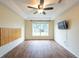 Spacious main bedroom with hardwood floors, large window, and recessed ceiling at 1421 Dew Bloom Rd, Valrico, FL 33594