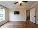 Main bedroom featuring hardwood floors, a ceiling fan, and a mounted television at 1421 Dew Bloom Rd, Valrico, FL 33594
