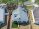 Aerial shot displaying a white house with a cozy backyard and sliding glass doors at 1421 Dew Bloom Rd, Valrico, FL 33594