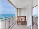 Enjoy alfresco dining on this balcony featuring a wood table with serene ocean views at 1430 Gulf Blvd # 707, Clearwater Beach, FL 33767