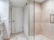 Bright bathroom featuring a glass shower with beige tiles, and a tile floor at 1430 Gulf Blvd # 707, Clearwater Beach, FL 33767