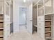 A large walk-in closet with custom shelving and drawers leading to ensuite bathroom at 1430 Gulf Blvd # 707, Clearwater Beach, FL 33767