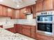 Stainless steel double oven with custom wood cabinetry and undermounted sink at 1430 Gulf Blvd # 707, Clearwater Beach, FL 33767