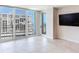 Bright living room featuring tile floors, large windows, and a stunning view of the surrounding city and waterway at 1430 Gulf Blvd # 707, Clearwater Beach, FL 33767