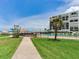 Inviting pool area and lounge chairs near the beach and condo with swaying palm trees and a grassy walkway at 1430 Gulf Blvd # 707, Clearwater Beach, FL 33767