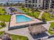 Aerial view of the community pool surrounded by palm trees and tiki huts at 1430 Gulf Blvd # 707, Clearwater Beach, FL 33767