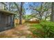 Backyard featuring a screened patio, grass, and wooden fence lined with mature trees at 14732 Morning Dr, Lutz, FL 33559