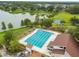 Aerial view of a pool next to a lake, with playground and basketball court at 14732 Morning Dr, Lutz, FL 33559
