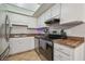 Efficient kitchen featuring white cabinets, a stainless steel oven, and a practical layout at 14732 Morning Dr, Lutz, FL 33559