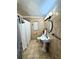 Bathroom with tiled walls, pedestal sink, and a shower with a white curtain at 1515 E Hanna Ave, Tampa, FL 33610