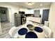 Modern kitchen with stainless steel appliances, white cabinets, and a cozy dining area at 1515 E Hanna Ave, Tampa, FL 33610