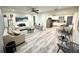 Open-concept living room featuring hardwood floors, modern decor, and seamless flow to the kitchen at 1515 E Hanna Ave, Tampa, FL 33610