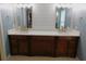Modern bathroom featuring dual sinks, white countertops, dark wood cabinetry, and elegant gold fixtures at 15916 Marshfield Dr, Tampa, FL 33624
