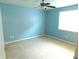 Bright bedroom with a ceiling fan, neutral carpet, and a large window for natural light at 15916 Marshfield Dr, Tampa, FL 33624