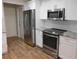 Updated kitchen featuring stainless steel appliances, white cabinets, and granite countertops at 15916 Marshfield Dr, Tampa, FL 33624