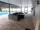 Covered patio with a comfortable seating area, pool, and outdoor lighting at 15916 Marshfield Dr, Tampa, FL 33624